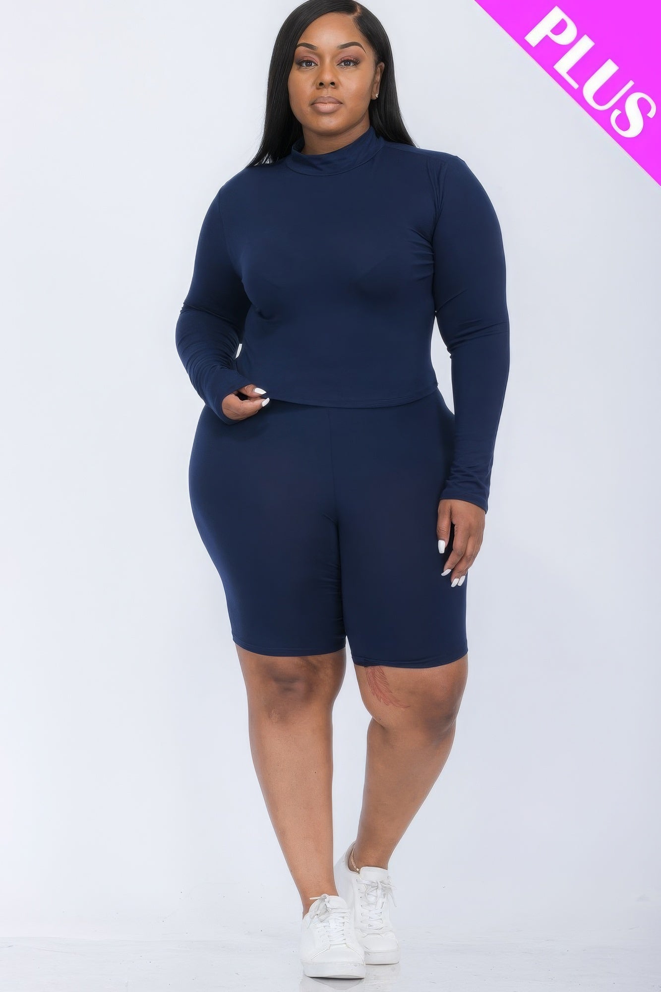 Plus-size woman wearing navy mock neck top and biker shorts set, showcasing style and comfort for curvy figures.