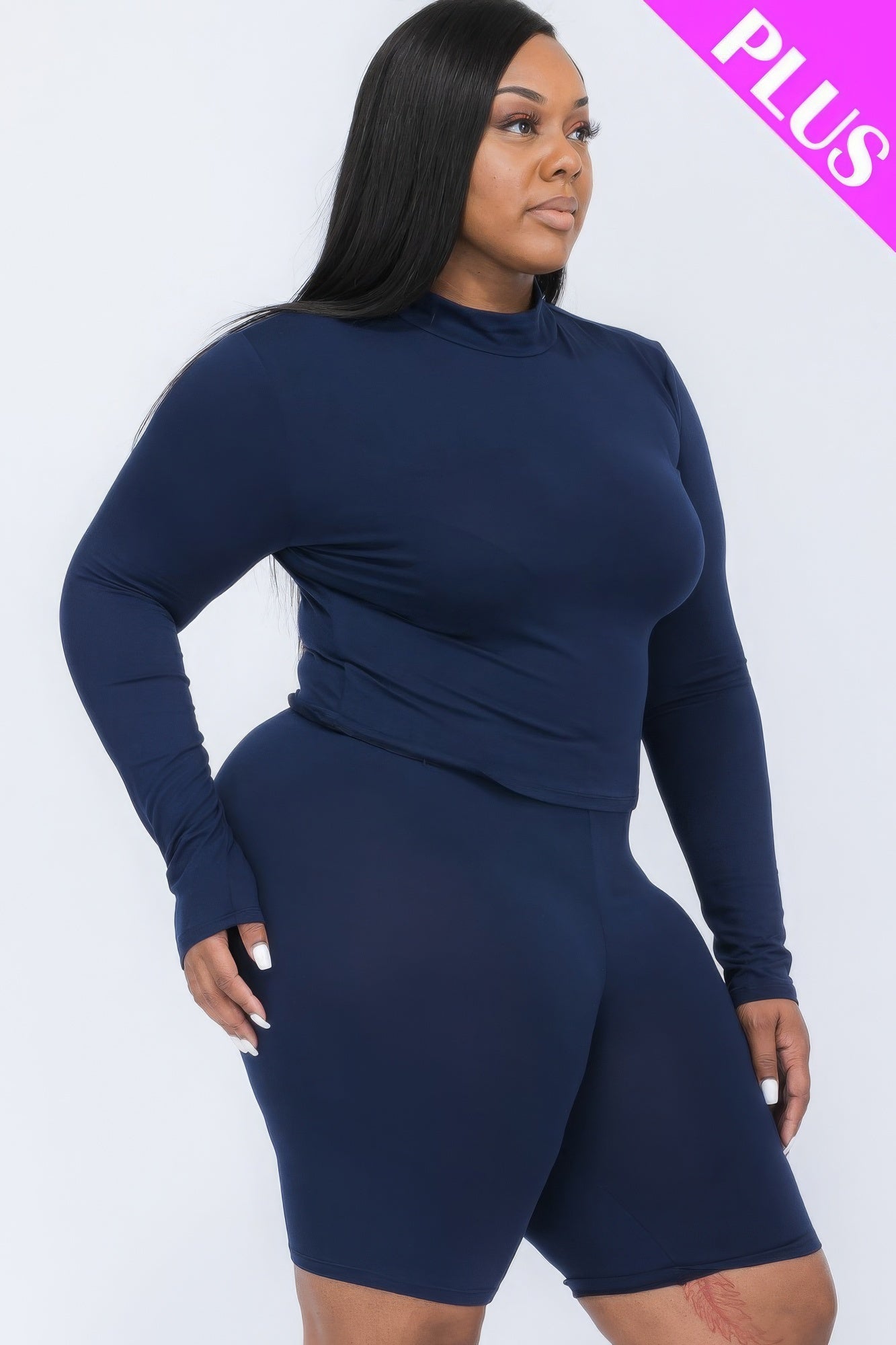 Plus-size model wearing a navy mock neck top and biker shorts set, showcasing a stylish and comfortable fashion ensemble.
