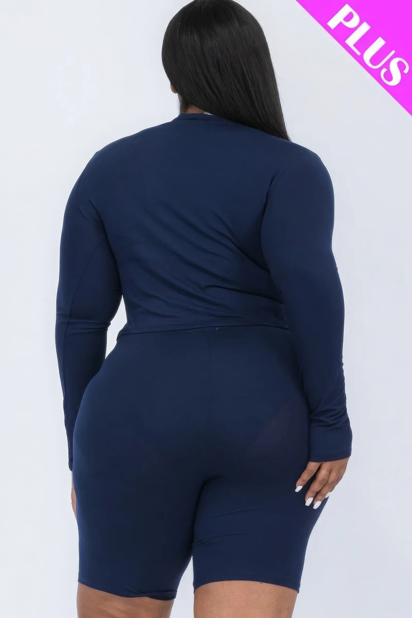 Plus-size woman modeling navy mock neck top and biker shorts set, back view.