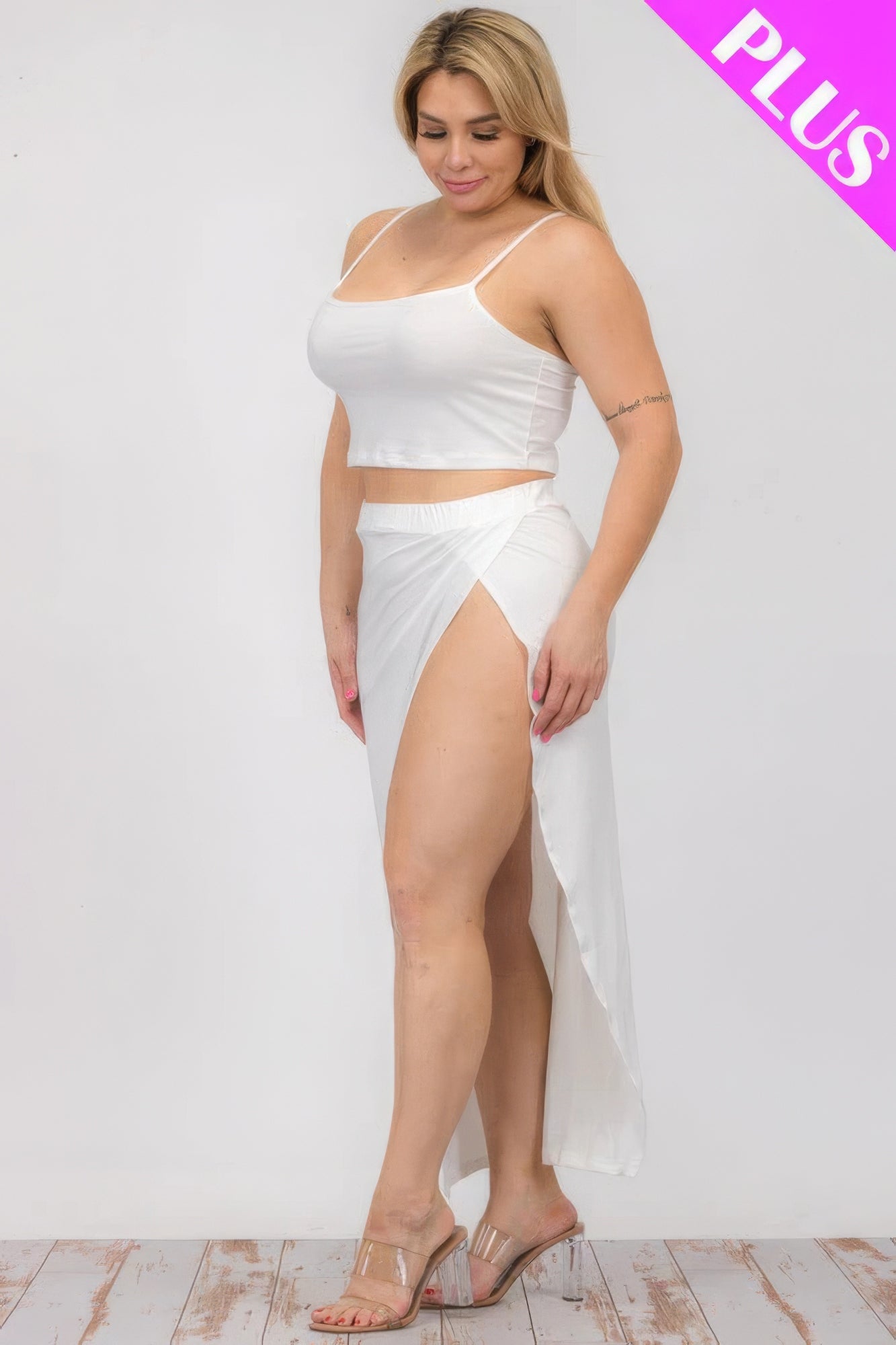 Plus size model in white crop cami and split thigh maxi skirt set showcasing stylish and comfortable fashion options.