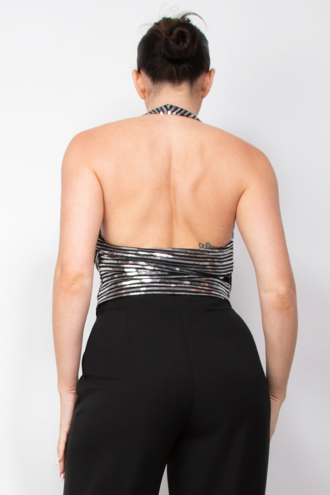 Woman wearing Surplice Halter Sequin Top by Love It Clothing, showcasing elegant backless design, perfect for special events.