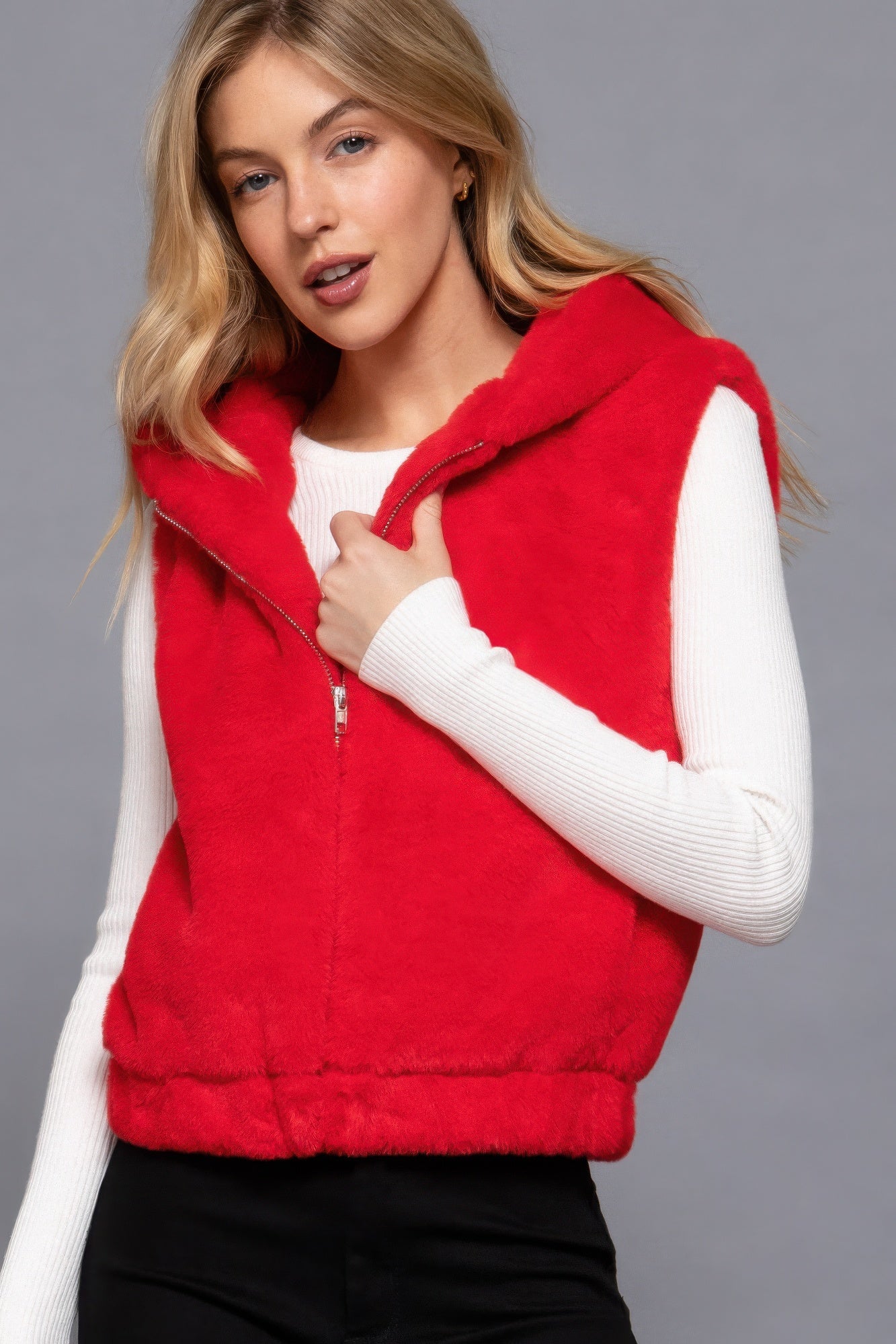 Woman wearing a red faux fur hoodie vest by Love It Clothing, ideal for layering and adding luxury to any outfit.