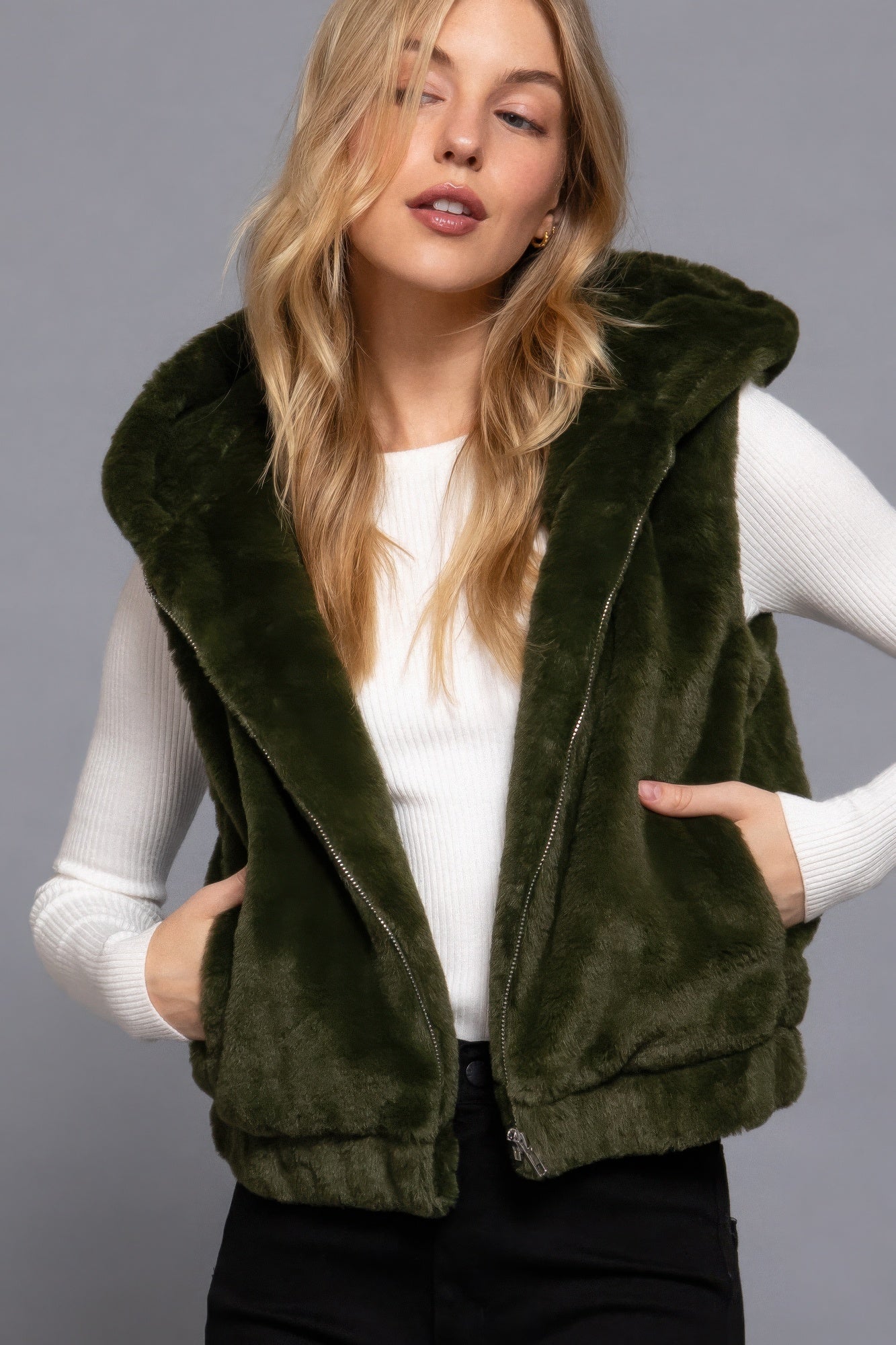 Woman wearing green faux fur vest with hoodie by Love It Clothing, perfect for layering and adding warmth to outfits.