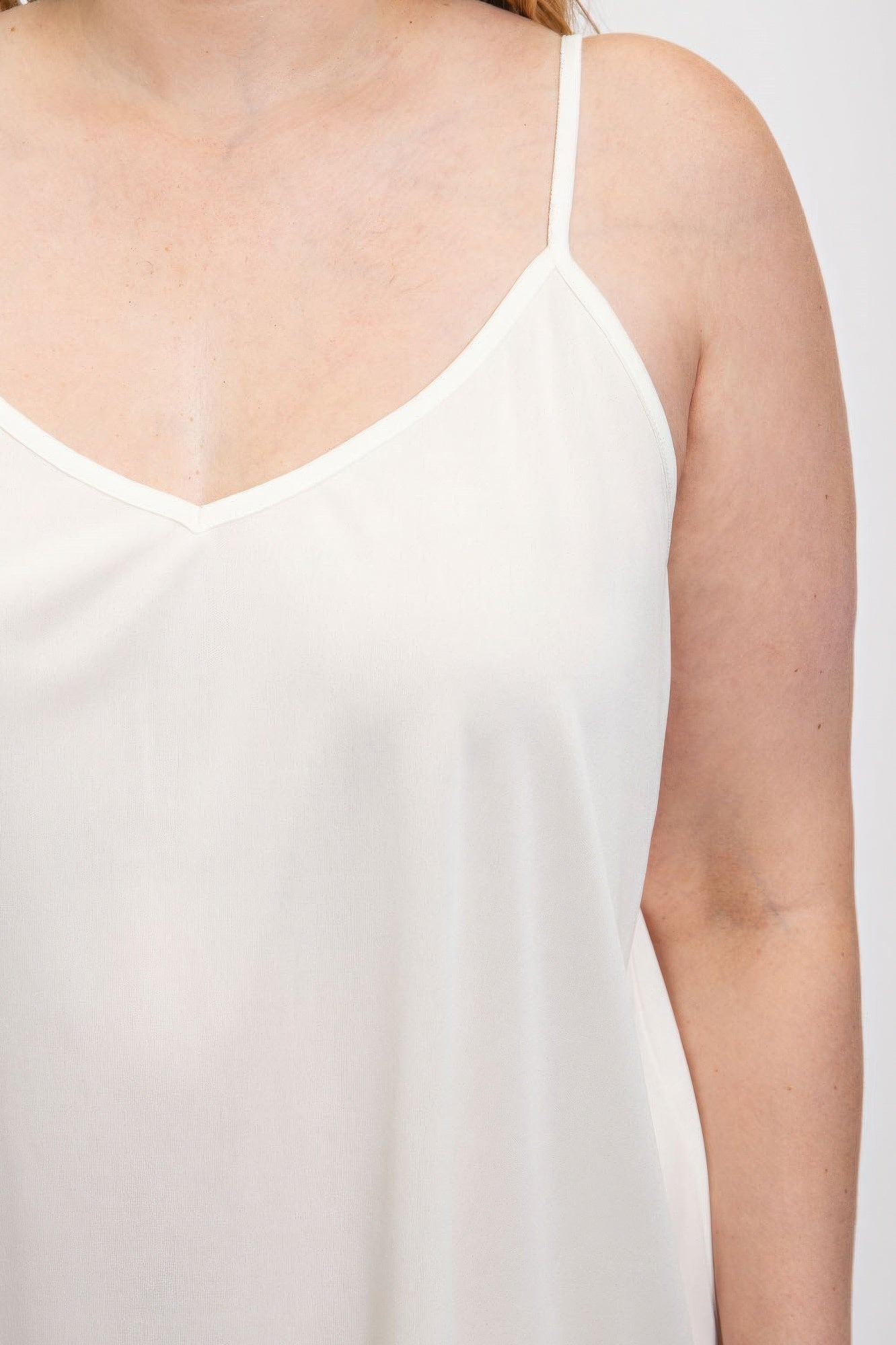 White V-neck slip dress with adjustable straps from Loveitclothing.com, showcasing a sleek polyester fabric for elegant style.