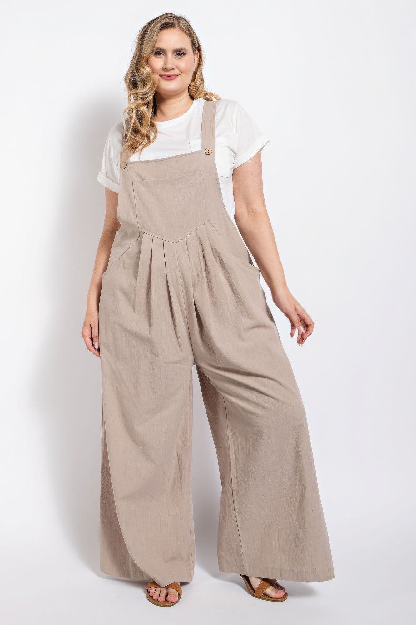 Woman wearing a stone cotton overall with pintuck details and side pockets from Loveitclothing.com.