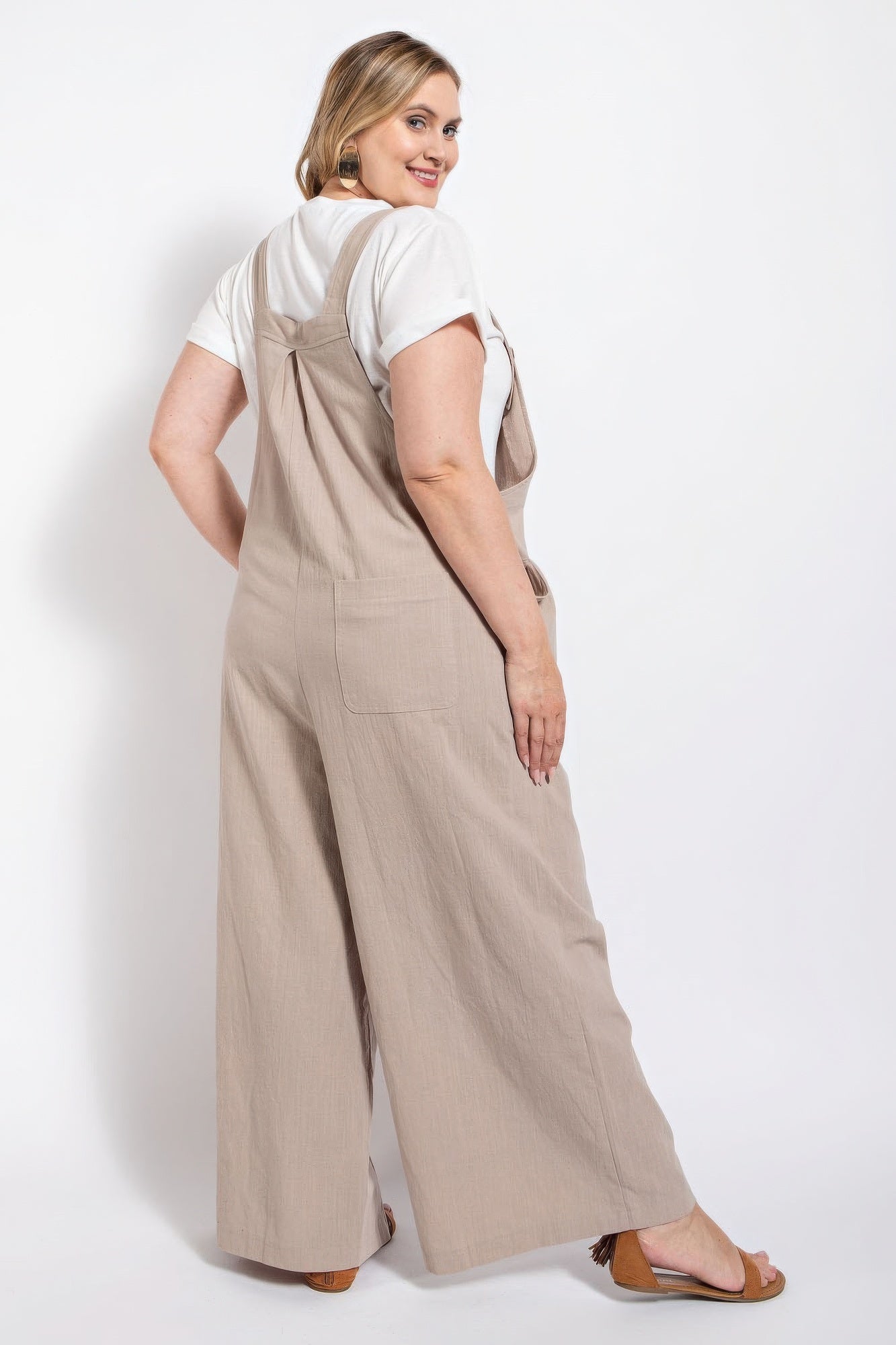 Woman wearing Loveitclothing.com stone pintuck detail overall with side pockets, crafted from 100% cotton for casual elegance.