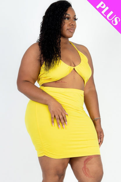 Plus size model in yellow crisscross halter top and ruched mini skirt set, showcasing stylish trendy fashion.