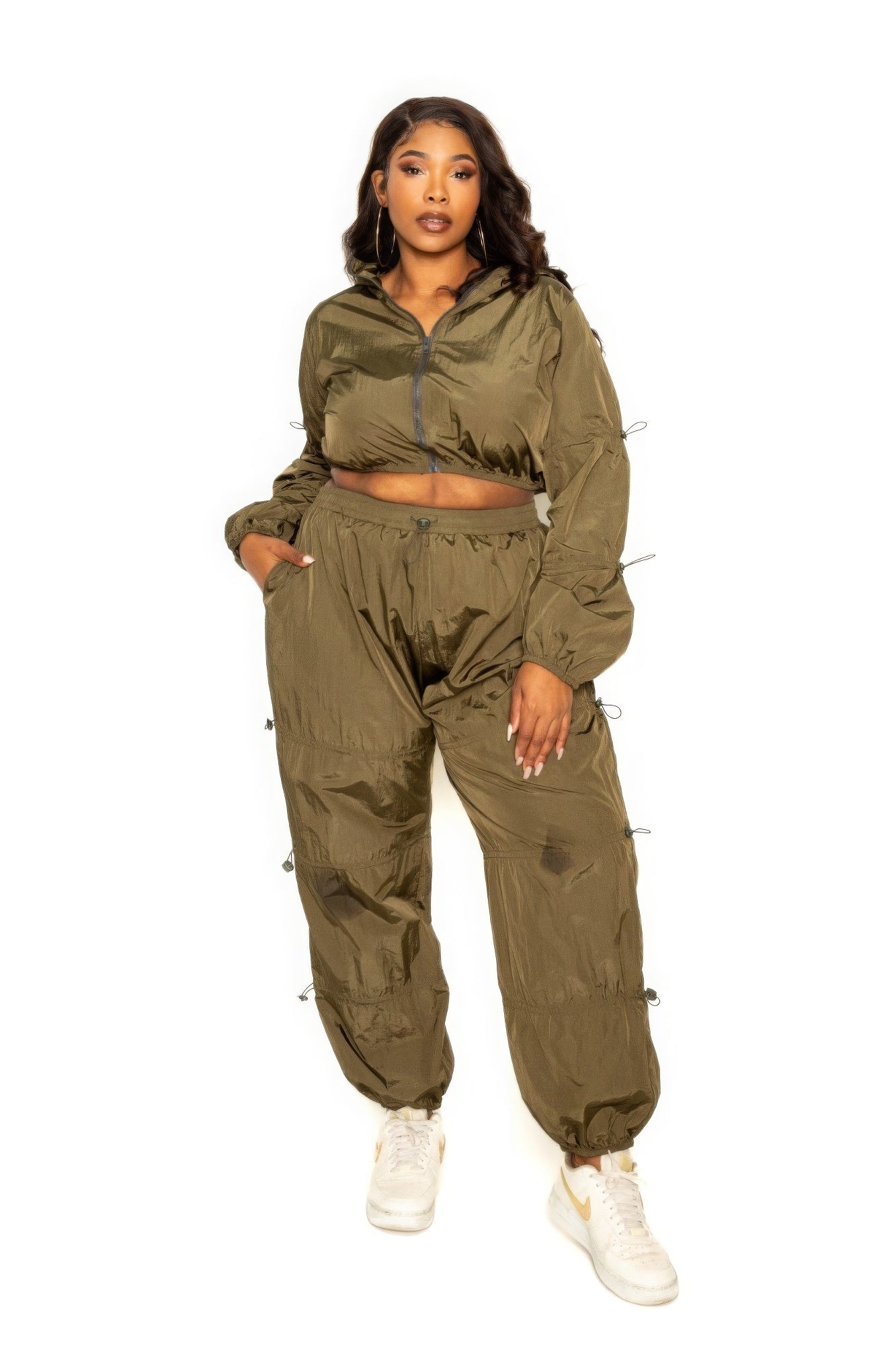 Plus-size model wearing olive green active zip up set with cord lock detail, perfect for stylish and comfortable workouts.