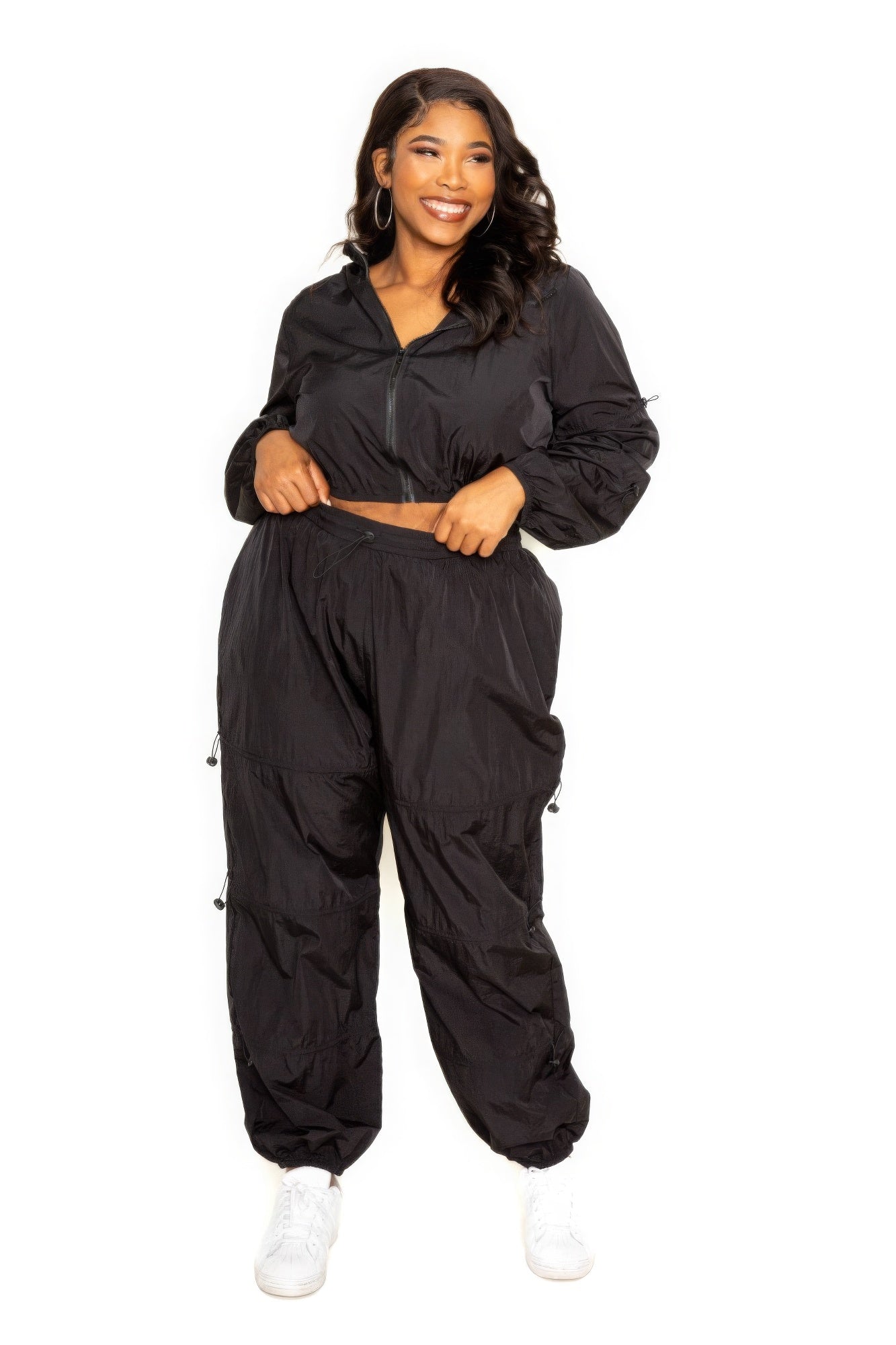 Woman wearing a black active zip-up set with cord lock detail, plus size activewear in extended sizes 1XL to 3XL, comfortable and stylish for workouts.