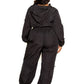 Plus-size model wearing black active zip-up set with cord lock detail from back view, highlighting comfortable fit and style.