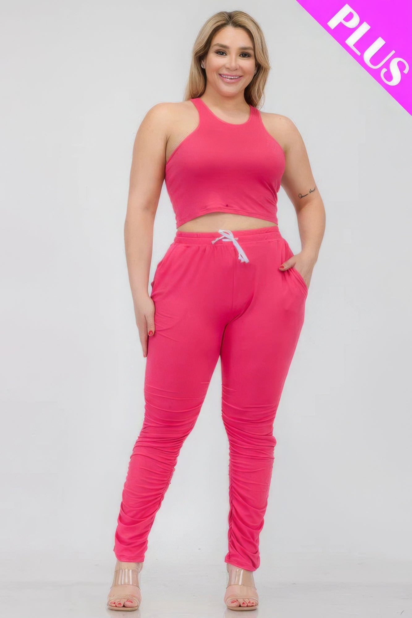 Plus size woman wearing a pink crop tank top and ruched pants set, emphasizing comfort and style.