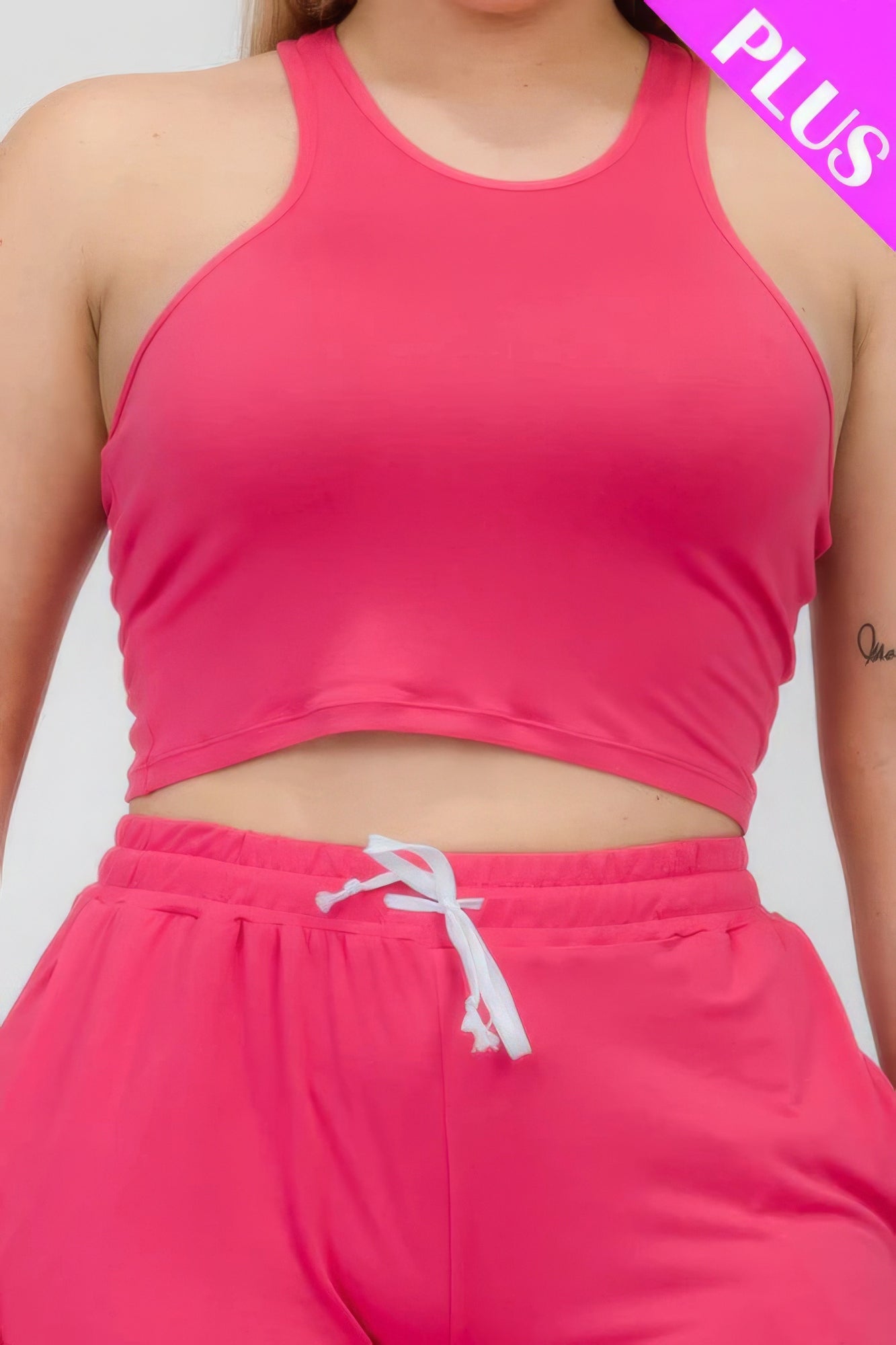 Plus size pink crop tank top and ruched pants set made of polyester and spandex for stylish comfort.