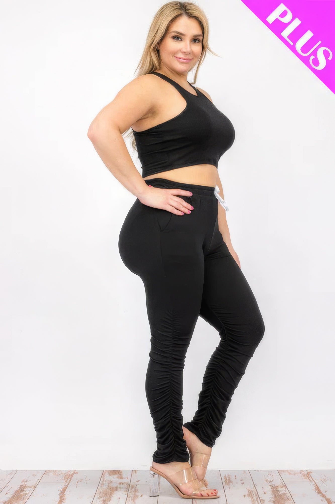 Plus size model wearing black crop tank top and ruched pants set for stylish comfort.