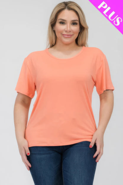 Plus size woman modeling a coral short sleeve t-shirt from Loveitclothing.com, showcasing comfort and style in a relaxed fit.