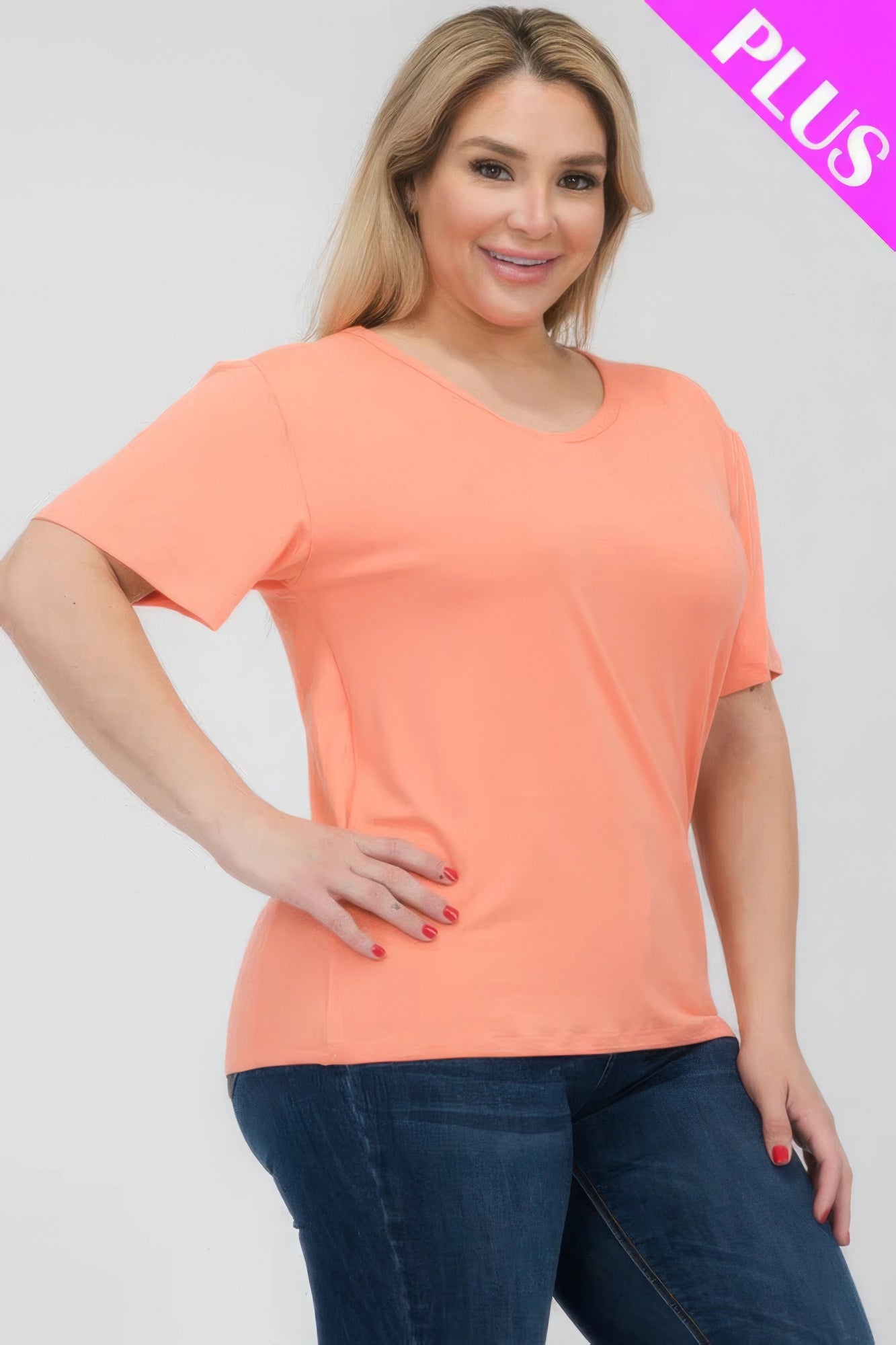 Model wearing a Plus Size Basic Short Sleeve T-shirt in peach, showcasing a soft and stretchy fit from Loveitclothing.com.