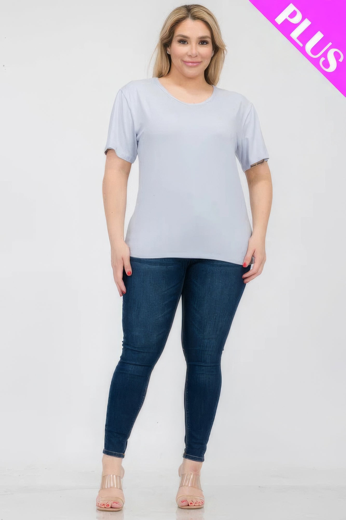 Plus size woman wearing a light blue short sleeve t-shirt paired with dark jeans, showcasing comfort and style from Loveitclothing.com.