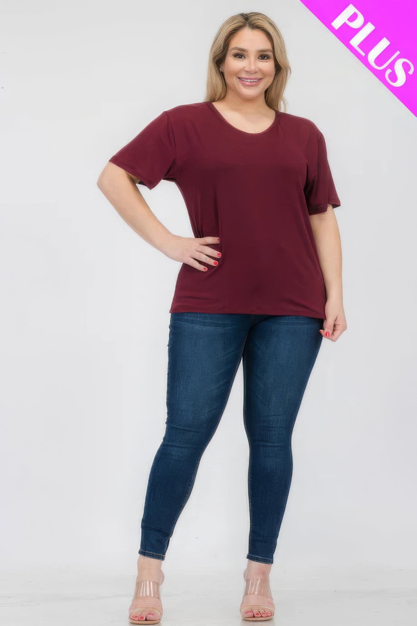 Model showcasing Plus Size Basic Short Sleeve T-shirt in maroon, paired with fitted jeans, from Loveitclothing.com.