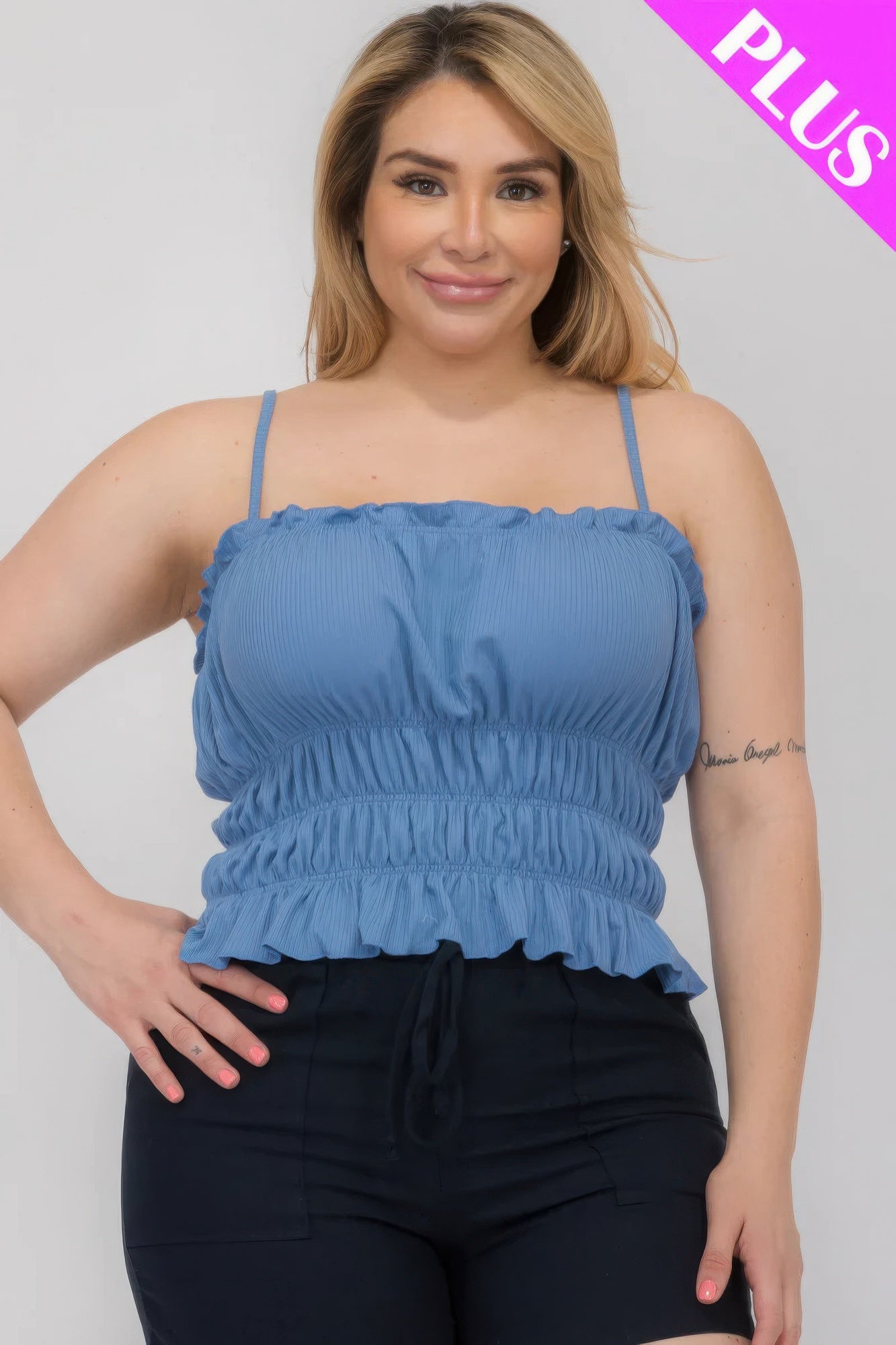 Plus size woman wearing a blue tiered crop top with shirred detailing, showcasing a stylish look for Loveitclothing.com.