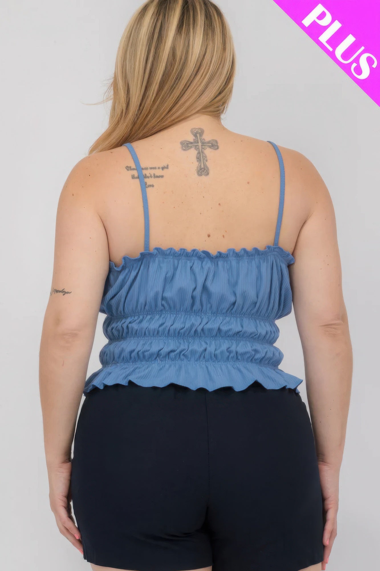 Plus size woman wearing a blue shirred body crop top with adjustable straps, back view, showcasing stylish and comfortable design.