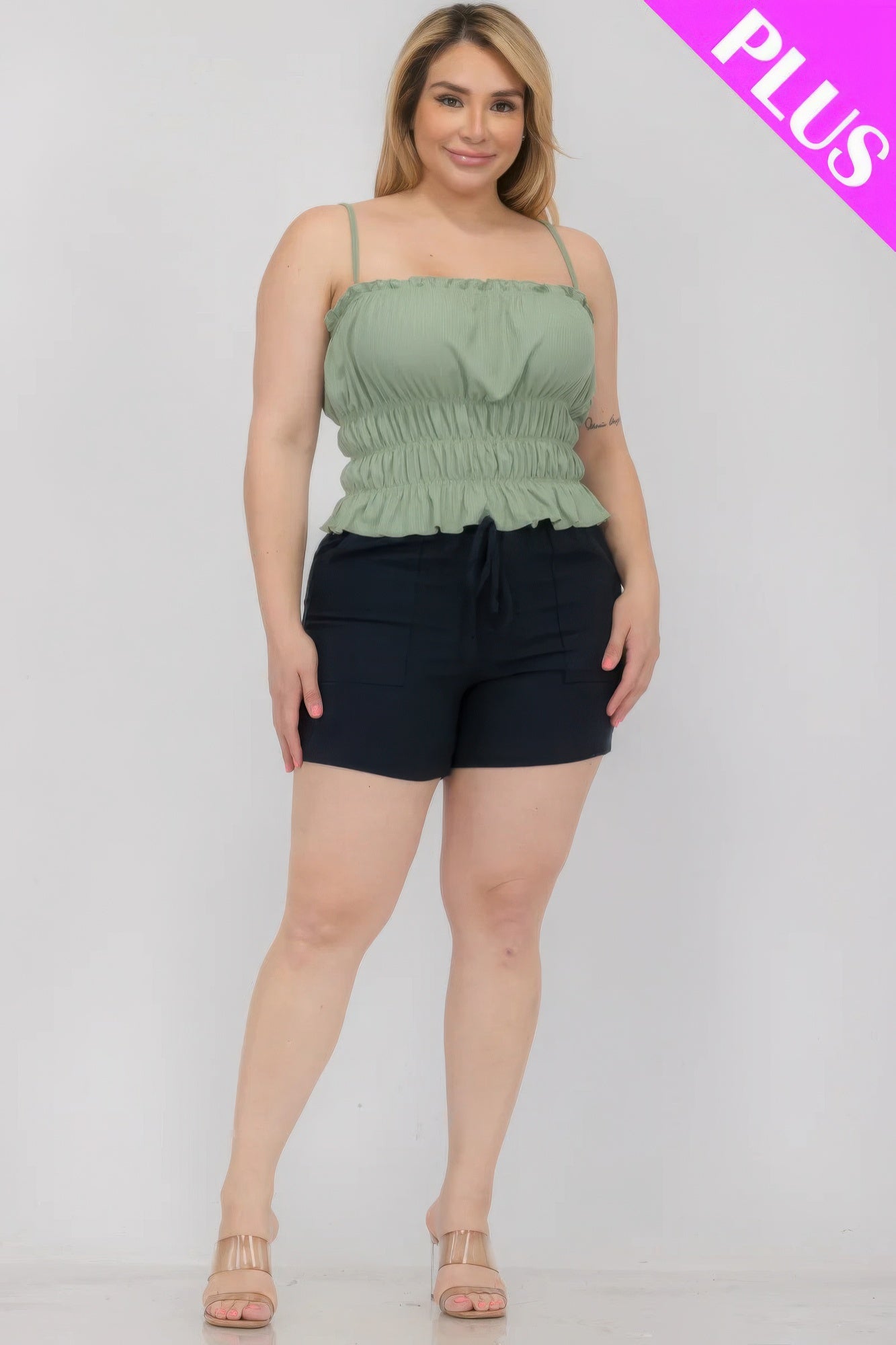 Plus size model wearing green shirred body crop top and black shorts from Loveitclothing.com