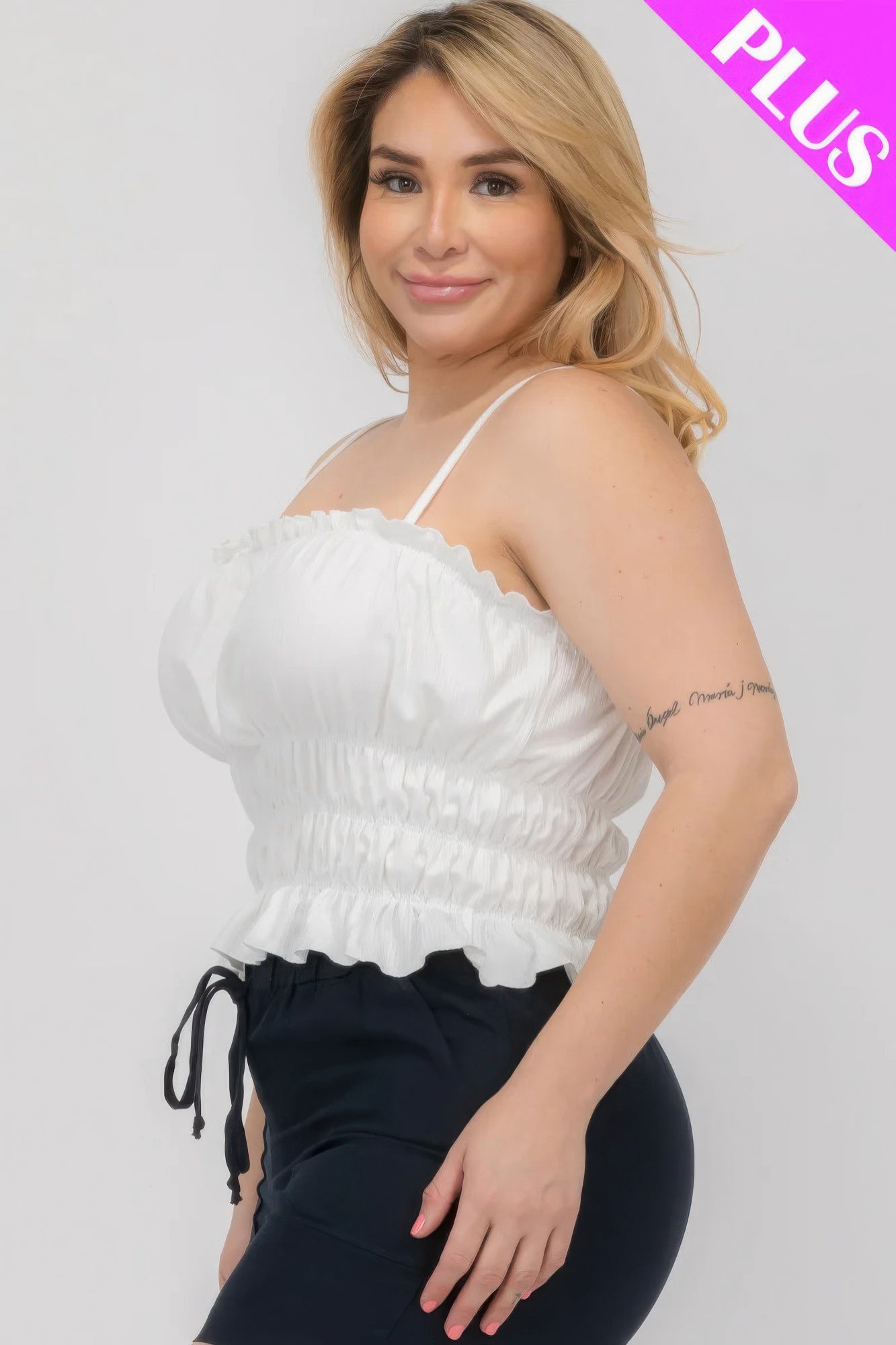 Plus size woman wearing white tiered shirred body crop top from Loveitclothing.com, showcasing a stylish and comfortable fit.