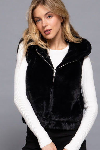 Woman wearing Hoodie Faux Fur Vest in black, Love It Clothing, warm and stylish outerwear for layering.