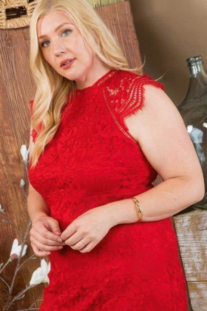 Woman wearing a red lace crochet dress with a raglan sleeve design, standing indoors.