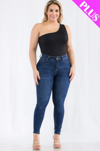 Plus size woman wearing a chic one shoulder black bodysuit with high-waisted denim jeans, showcasing a stylish casual look.