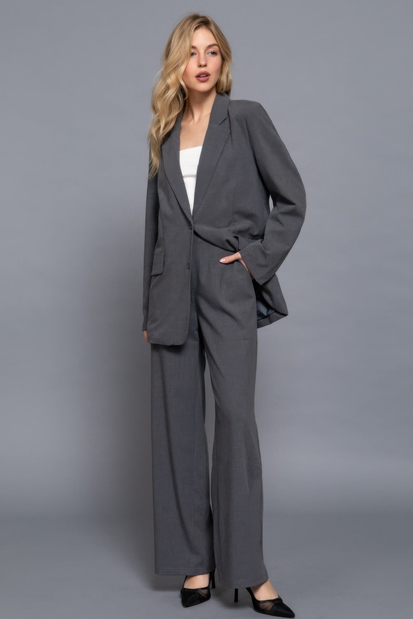 Stylish woman in gray blazer and wide-leg pants, showcasing modern elegance and sophistication for a professional look.