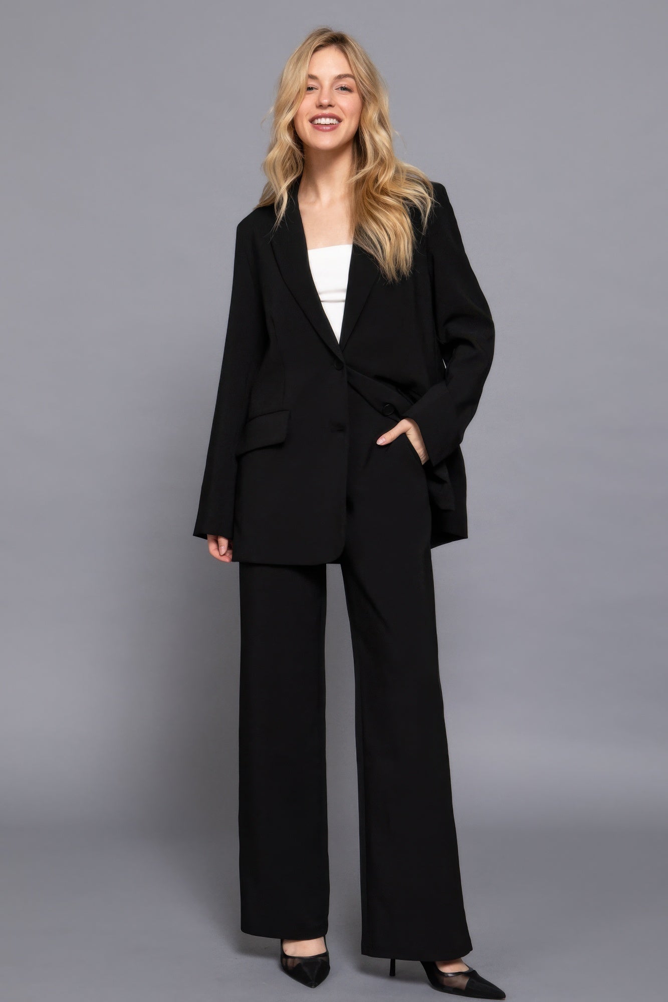 Woman wearing black back elastic straight woven long pants with a blazer and black heels, exuding confidence and style.