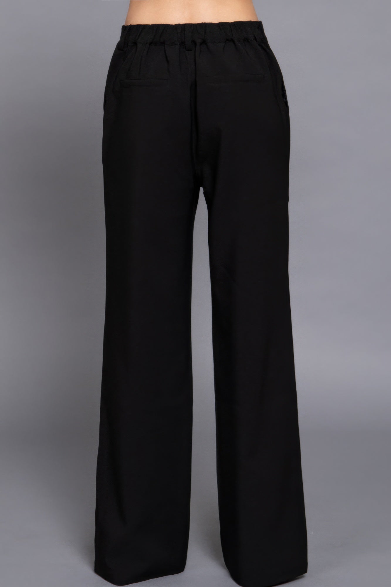 Back view of black back elastic straight woven long pants with a relaxed fit and pockets. Loveitclothing.com.